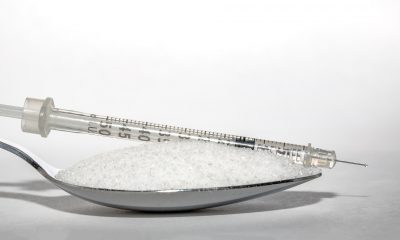 insulin syringe over spoon of sugar